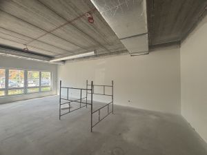 Sala przedszkolna pomalowana pierwszą warstwą farby, na środku stoi rusztowanie